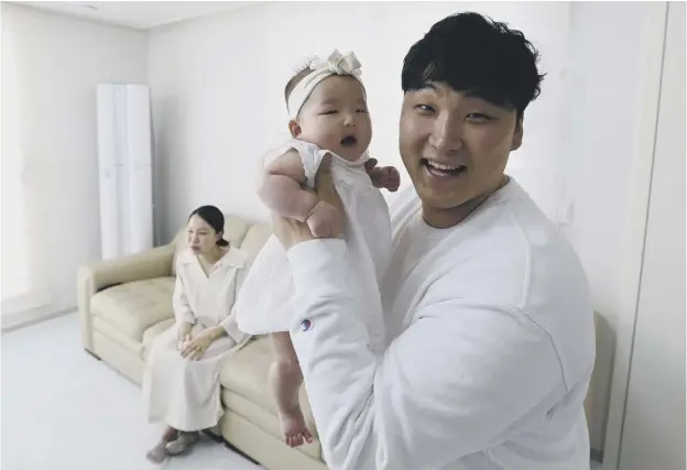  ??  ?? Lee Dong Kil with his daughter Lee Yoon Seol and wife Ryu Da Gyeong at their house in Daejeon, South Korea