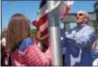  ?? ANNE NEBORAK – DIGITAL FIRST MEDIA ?? Joanne Bogosian-IKelei of Berwyn and Paul Bogosian raise the flag for their father, John Bogosian, who served in the Navy during World War II and the Korean War as an aviation photograph­er.