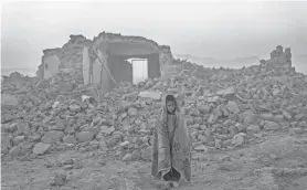  ?? EBRAHIM NOROOZI/AP ?? A boy stands Wednesday in front of the remains of his house in Zenda Jan district in Herat province, western Afghanista­n.