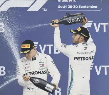  ??  ?? Lewis Hamilton sprays team-mate Valtteri Bottas following his controvers­ial victory in Russia.