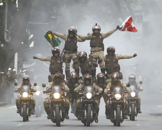  ??  ?? A pirâmide humana, formada por policiais militares, é uma das grandes atrações do desfile cívico-militar; PMs carregaram bandeiras do Brasil e da Bahia