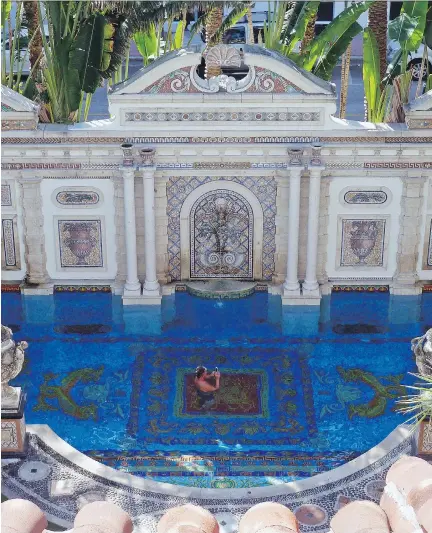  ?? JENNIFER KAY/ THE ASSOCIATED PRESS ?? Tourists lounge in the 24-karatgold-tiled pool at The Villa Casa Casuarina, which was the former home of fashion designer Gianni Versace.