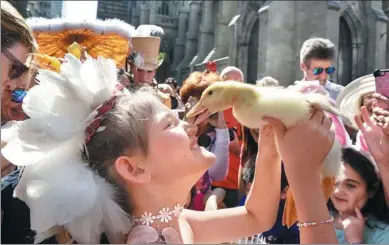  ?? STEPHANIE KEITH / GETTY IMAGES ?? A woman holds a duck during the Easter Parade and Bonnet Festival along 5th Avenue in New York City on Sunday. The pageant is an annual tradition that stretches back to the 1870s.