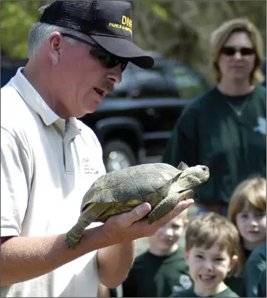  ?? (File Photo/AP/ Elliott Minor) ?? Park Ranger Chet Powell shows a gopher tortoise to an elementary school class April 11, 2004, at Reed Bingham State Park near Adel, Ga.