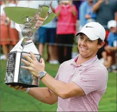  ?? CURTIS COMPTON / CCOMPTON@AJC.COM ?? Rory McIlroy hoists the FedEx Cup after winning the PGA Tour Championsh­ip and $15 million dollars last month at East Lake Golf Club. The new PGA season begins this week.