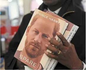  ?? ?? a man holds three copies of the book Spare by Britain’s Prince Harry during a recent special midnight event for the release of the memoir at a bookshop at in London. — AFP