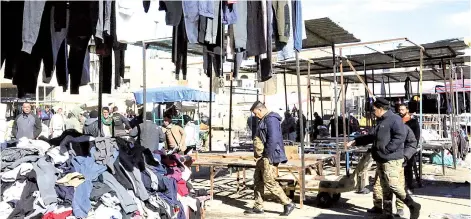  ?? — AFP photo ?? Life returns to the used clothing market in Baghdad, two days after a twin suicide bombing there killed at least 32 people and wounded more than 110 others.