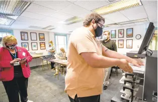  ?? THE’N. PHAM/STAFF ?? Assistant registrar Anthony Vinogradov places mailed ballots to scan and tabulate at the Virginia Beach Department of Voter Registrati­on & Elections in Virginia Beach on Oct. 2. When the poll closes on Nov. 3, the machine will analyze the results from the scanned ballots.