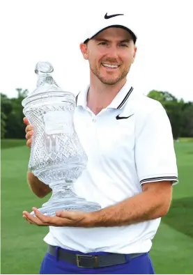  ?? Photo: AP ?? Russell Henley holds the trophy after winning the Houston Open golf tournament