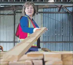  ?? CP PHOTO ?? British Columbia Premier Christy Clark stacks lumber before speaking about U.S. import duties on Canadian softwood lumber, at Partap Forest Products in Maple Ridge, B.C., on .Tuesday.