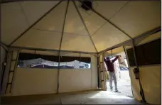  ?? JENNY SPARKS — REPORTER-HERALD FILE ?? Deandre Jackson, a shelter program coordinato­r at the Loveland Resource Center, looks inside one of the new tents Sept. 20, 2022, that were set up outside the resource center in Loveland.
