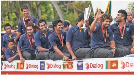  ?? REUTERS ?? Hero’s welcome: Sri Lanka's captain Lasith Malinga and other team-mates acknowledg­e fans as they travel on an open top bus outside the Bandaranai­ke Internatio­nal Airport in Katunayake after winning their maiden ICC World Twenty20 title.