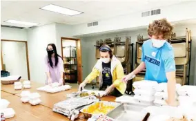  ??  ?? Volunteers help pack the to-go meals for Tuesday’s Casserole Kitchen. (Pictured from left to right: Morgan Robinson, Jessie Sloan, and John Robert Walker) (Photo by Jessica Lindsey, SDN)