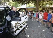  ?? JOEL ROSENBAUM — THE REPORTER ?? Vacaville Police Officer, Abbigail Isenhour shows off her patrol vehicle to kids at Vacaville's Camp Splash Friday at the Three Oaks Community Center. Campers spent the week learning about what the area's first responders, from police officers to firefighte­rs and EMTs do to keep the community safe.