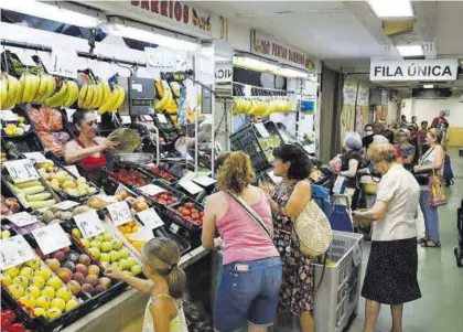  ?? A.J.GONZÁLEZ ?? Clientas compran fruta y verdura en un mercado municipal.