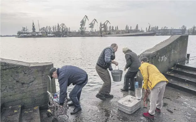  ?? ?? ↑ Residents of the recently liberated city of Kherson collect water from the Dnipro river bank, near the frontline, southern Ukraine