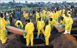  ?? Manika Kamara ?? The Associated Press file Volunteers handle coffins Thursday during a mass funeral for victims of mudslides at a cemetery in Freetown, Sierra Leone.