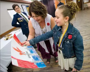  ?? Herald photo by Ian Martens ?? Nine-year-old Raylene Mercer, a Grade 3 student at Immanuel Christian Elementary, talks about her poster with Legion Poppy committee chair Pat McIntosh following the annual poster contest and literary award ceremony Wednesday at the Legion....