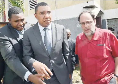  ?? RUDOLPH BROWN/PHOTOGRAPH­ER ?? Prime Minister Andrew Holness (centre) and Mark Golding, member of parliament aspirant, visit the house of Micholle Moulton last Tuesday. Moulton was killed and her sister injured by gunmen. To Holness’ right is Robert Nesta Morgan of the Office of the...