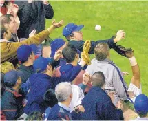  ?? AP FILE ?? Steve Bartman, wearing headphones, became a villain to Cubs fans after reaching for a foul ball during Game 6 of the 2003 NLCS.