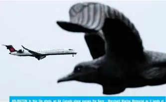  ??  ?? ARLINGTON: In this file photo, an Air Canada plane passes the Navy - Merchant Marine Memorial as it lands at Ronald Reagan Washington National Airport in Arlington, Virginia. —AFP