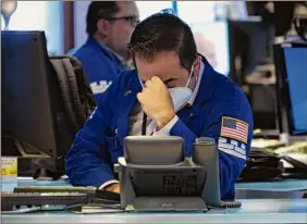  ?? Spencer Platt / Getty Images ?? Traders work on the floor of the New York Stock Exchange on Wednesday in New York City. The Dow Jones Industrial Average fell over 1,000 points.