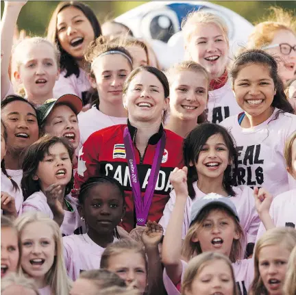  ?? IAN KUCERAK ?? Soccer players pose for a photo with Team Canada’s Diana Matheson during halftime at a NASL game between FC Edmonton and Indy Eleven on May 27 at Clarke Stadium in Edmonton. Matheson, 33, says it’s “always great to meet kids in this community.”