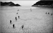  ?? ASSOCIATED PRESS ?? PEOPLE WALK ALONG THE SAND at La Concha beach in the Basque city of San Sebastian, northern Spain, on Wednesday.