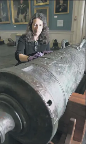  ?? PICTURE: PA WIRE. ?? Diana Davis, senior conservato­r at the National Museum of the Royal Navy in Portsmouth Historic Dockyard, inspects the 42-pound cannon from HMS Victory 1744 after it was moved into position. BIG HITTER: