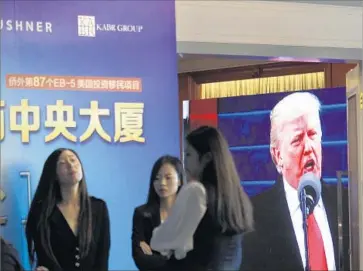  ?? Associated Press ?? A PROJECTOR SCREEN shows footage of President Trump as workers wait for investors during an event Sunday at a Shanghai hotel to promote an EB-5 visa investment in a Kushner Cos. developmen­t in New Jersey.