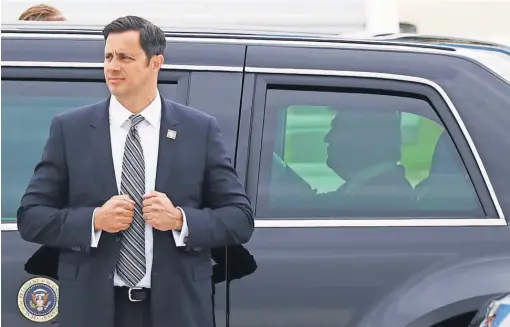  ?? THOMAS SAMSON, AFP/ GETTY IMAGES ?? A bodyguard stands in front of President Trump’s car after he disembarke­d from Air Force One in Paris July 13.