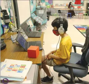  ?? The Associated Press ?? Nova Blanche Forman Elementary School teacher Attiya Batool, teaches her fourth grade class virtually as her son, Nabeel, does his second grade classwork during the first day of school in in Davie, Fla. This year, many families are dealing with a first: building their back-to-school shopping plans around distance learning. As the COVID-19 pandemic leads students to take on instructio­n at home rather than in the classroom, consumers expect to spend more on backto-school purchases in 2020 than last year.