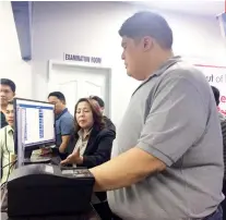  ?? SUNSTAR FOTO / FLORNISA MARIE M. GITGANO ?? LICENSING CENTER. Mandaue City Mayor Luigi Quisumbing tries on a machine of the LTO licensing center, which can now issue the driver’s license valid for 5 years.