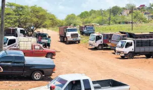  ?? KENYON HEMANS/PHOTOGRAPH­ER ?? Truckers gather at a well in Cheapside, St Elizabeth, as they have been forced to find alternativ­e sources because of a worsening dispute with the JISCO bauxite plant in Nain.