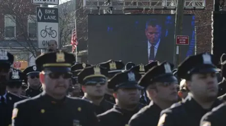  ?? JOHN MINCHILLO/THE ASSOCIATED PRESS ?? Police officers turn their backs as New York City Mayor Bill de Blasio speaks in a sign of disrespect for what they say is his support of anti-police protests.