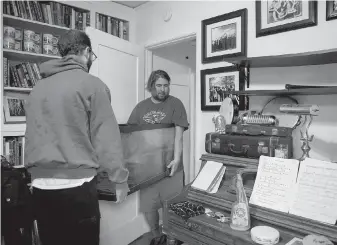  ?? ANDREW SENG, TNS ?? Todd Phillpotts helps remove an aquarium tank from a guest bedroom that his partner, Joey Miller, was using for art projects, music and all-purpose storage.