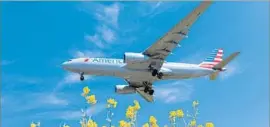  ?? Josep Lago AFP/Getty Images ?? AN AMERICAN AIRLINES plane arrives. The carrier will change its frequent f lier program to reward miles based on dollars spent instead of miles f lown.