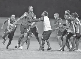  ?? -Gambar AFP ?? PEMAIN Trinidad and Tobago’s Alvin Jones (dua kiri) bersama pasukan meraihkan selepas menjaringk­an gol ke atas Amerika Syarikat ketika kempem kelayakan Piala Dunia 2018 di Couva, Trinidad and Tobago.