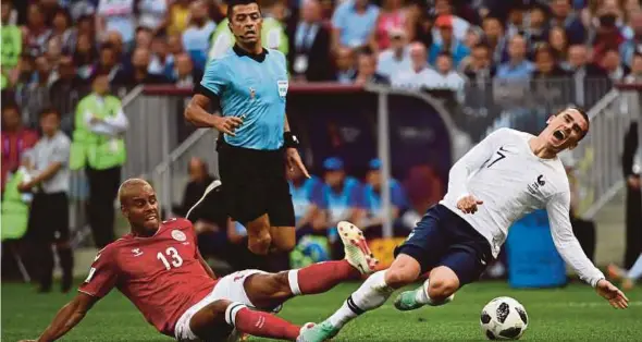  ?? AFP PIC ?? Denmark’s Mathias Jorgensen (left) challenges France’s Antoine Griezmann at the Luzhniki Stadium yesterday.