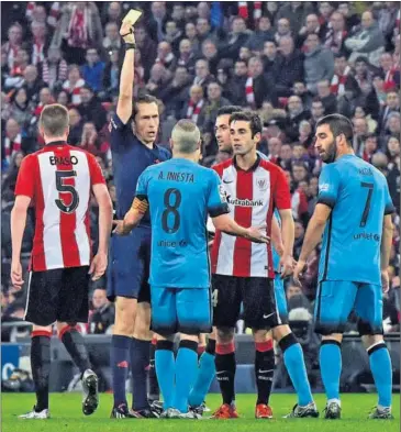  ??  ?? INFLEXIBLE. González González saca tarjeta a Iniesta en Bilbao.
