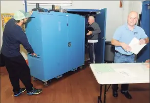  ?? Ned Gerard / Hearst Connecticu­t Media file photo ?? From left, Michael Gonzalez, Dave Siegler and Lou Decilio prepare to set of election polls at Bunnell High School in Stratford on Nov. 6, 2017. Secretary of the State Denise Merrill will announce this week guidelines for the coronaviru­s pandemic, based on her and her staff’s interpreta­tion of election laws.