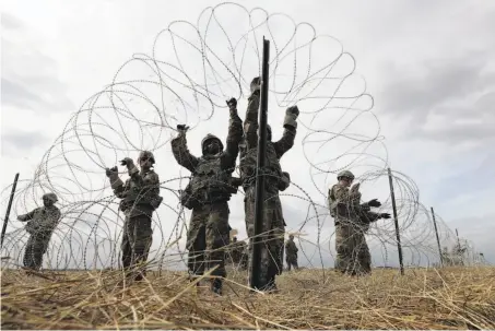  ?? Eric Gay / Associated Press ?? Members of a U.S Army engineerin­g brigade place concertina wire Nov. 4 around an encampment for troops in Donna, Texas.