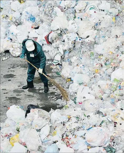  ??  ?? Un operario ordena plásticos sin clasificar en el centro de reciclado de Tsurumi, en Yokohama (Japón)