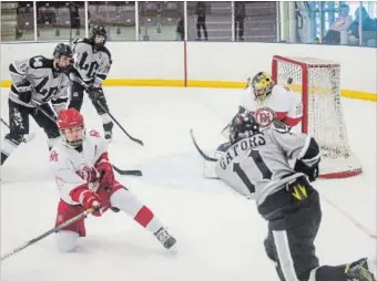  ?? BOB TYMCZYSZYN
THE ST. CATHARINES STANDARD ?? Lakeshore Catholic's Jacob Barnowski (11) ties the game up 2-2 on this shot over the should of Denis Morris goalie Mateo Lalama (29) during their SOSSA semifinal game. Lakeshore edged Denis Morris 4-3 to advance to the final.