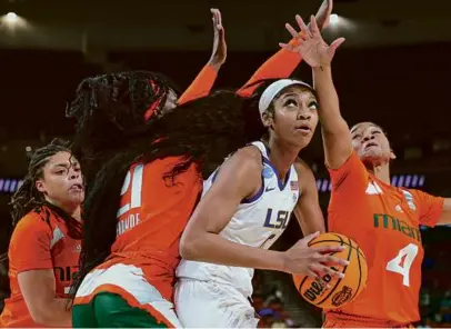  ?? KEVIN C. COX/GETTY IMAGES ?? LSU’s Angel Reese had to contend with three Miami defenders, all while collecting 13 points and 18 rebounds to lead the Tigers to a 54-42 victory and a spot in the women’s Final Four.