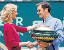  ??  ?? Winning image: Roger Federer receives his trophy at the Halle Open from model Eva Herzigova