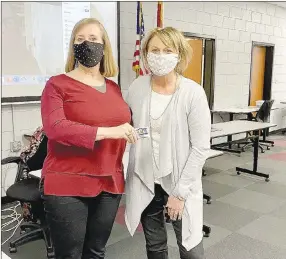  ?? COURTESY PHOTO ?? Mary Ann Spears, superinten­dent of Lincoln Consolidat­ed School District, right, congratula­tes high school teacher Patricia Myers, who was given the Above and Beyond Award for February.