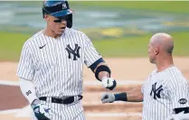  ?? GREGORYBUL­L/AP ?? Yankees’Aaron Judge, left, bumps fists with Brett Gardner after Gardner scored on Judge’s sacrifice fly against the Rays during the third inning on Wednesday in San Diego.