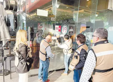  ?? ?? l Personal de la Dirección General de Bebidas Alcohólica­s coloca los sellos de clausura en la Cervecería 19 de Plaza Andenes.