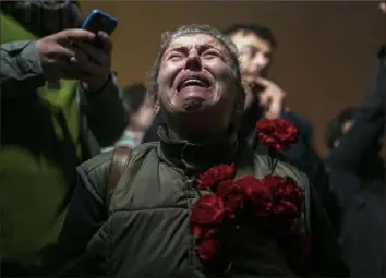  ?? ?? A woman cries as she and others gather in a moment of silence Tuesday to mark the one-year anniversar­y of the country’s catastroph­ic earthquake in the city of Antakya, southern Turkey.